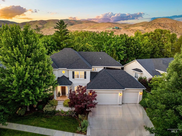 5446 E Branchwood Ct, Boise, ID 83716 - view of front of house with an attached garage, driveway, a mountain view, roof with shingles, and stucco siding