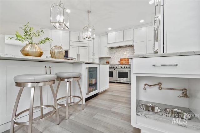 5446 E Branchwood Ct, Boise, ID 83716 - kitchen featuring paneled built in fridge, wall oven, wine cooler, premium range hood, and white cabinetry