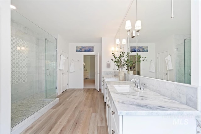 5446 E Branchwood Ct, Boise, ID 83716 - full bath with double vanity, a shower stall, wood finished floors, and a chandelier