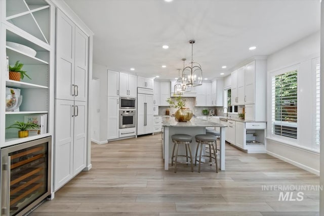 5446 E Branchwood Ct, Boise, ID 83716 - kitchen featuring beverage cooler, built in appliances, white cabinetry, open shelves, and light wood finished floors