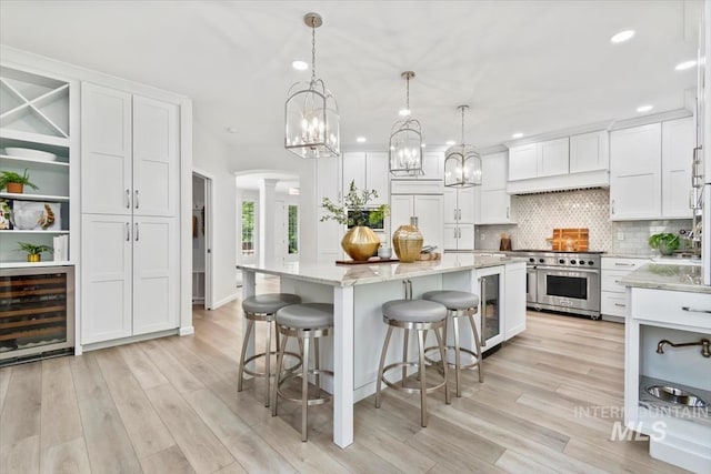 5446 E Branchwood Ct, Boise, ID 83716 - kitchen featuring beverage cooler, range with two ovens, white cabinetry, arched walkways, and recessed lighting