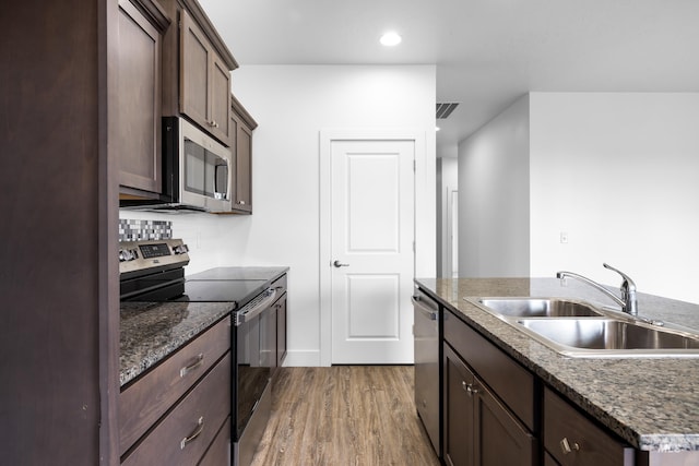 2928 W Los Flores Dr, Meridian, ID 83646 - kitchen with stainless steel appliances, a sink, wood finished floors, dark brown cabinetry, and recessed lighting