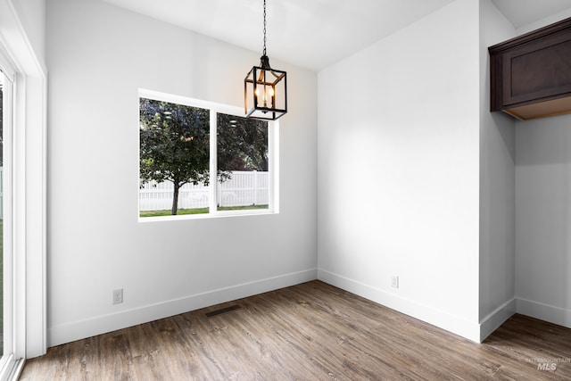 2928 W Los Flores Dr, Meridian, ID 83646 - unfurnished dining area featuring a chandelier, wood finished floors, and baseboards