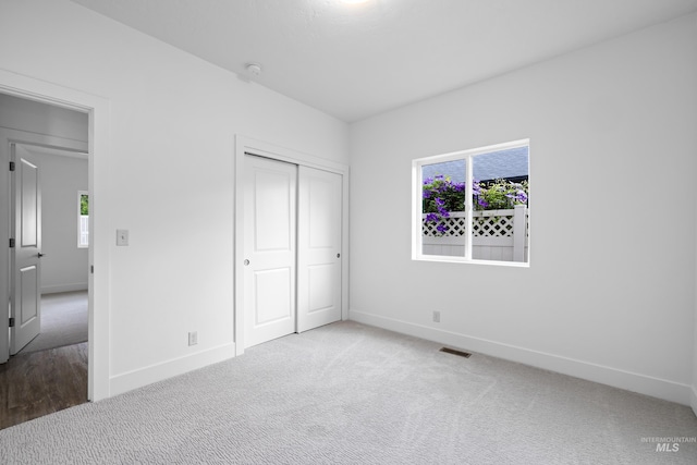2928 W Los Flores Dr, Meridian, ID 83646 - unfurnished bedroom with baseboards, multiple windows, carpet flooring, and a closet