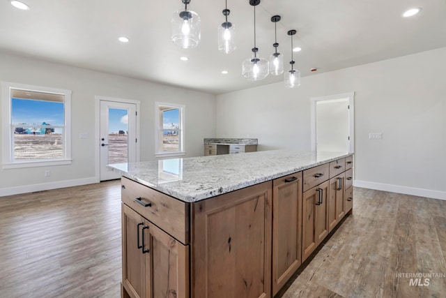 kitchen with light wood-style floors, a kitchen island, and recessed lighting