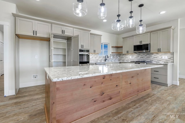 kitchen featuring light wood-type flooring, tasteful backsplash, appliances with stainless steel finishes, and open shelves