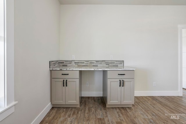 room details with baseboards, decorative backsplash, and wood finished floors