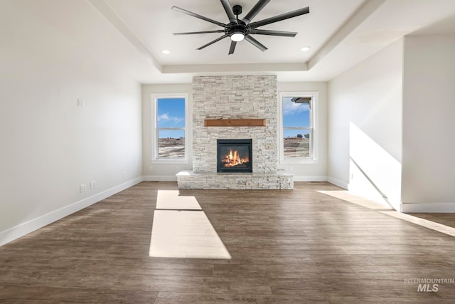 unfurnished living room featuring a raised ceiling and baseboards