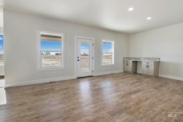 interior space featuring recessed lighting, light wood-style flooring, and baseboards