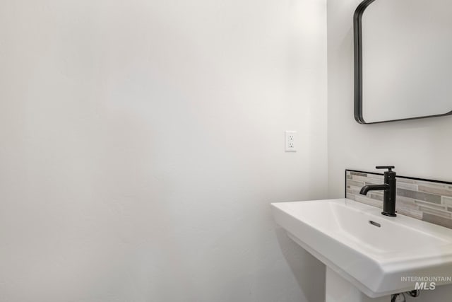 bathroom with tasteful backsplash and a sink