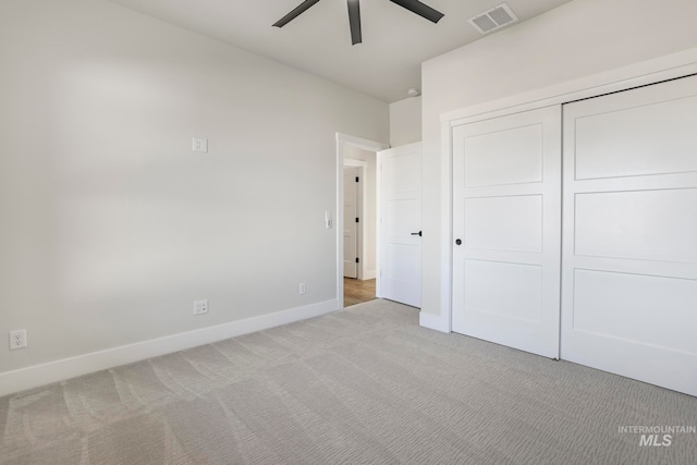 unfurnished bedroom featuring carpet floors, a closet, visible vents, ceiling fan, and baseboards