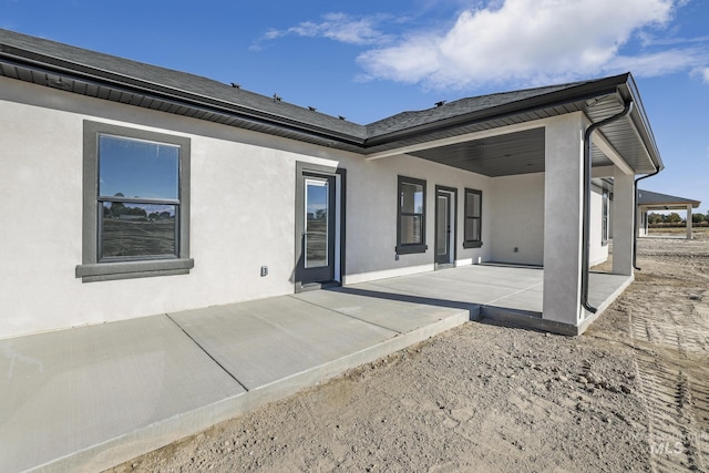 back of property with a patio area and stucco siding