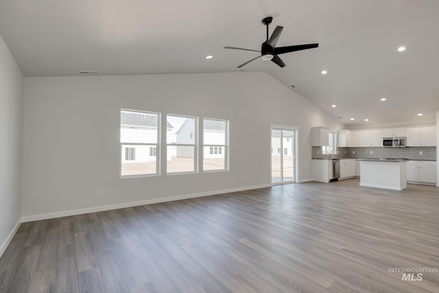 unfurnished living room with high vaulted ceiling, a ceiling fan, light wood finished floors, visible vents, and recessed lighting