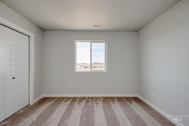 unfurnished bedroom featuring baseboards, visible vents, and carpet flooring