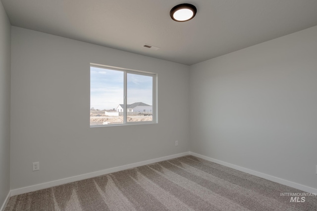 empty room featuring carpet flooring and baseboards