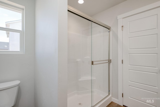 full bath featuring a shower stall and toilet