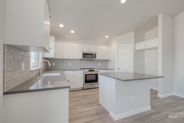 kitchen featuring recessed lighting, stainless steel appliances, a sink, light wood-style flooring, and tasteful backsplash