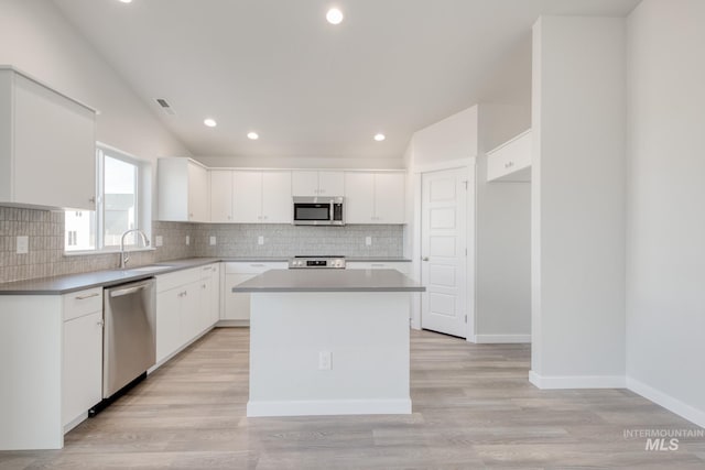 kitchen with backsplash, recessed lighting, stainless steel appliances, and a sink