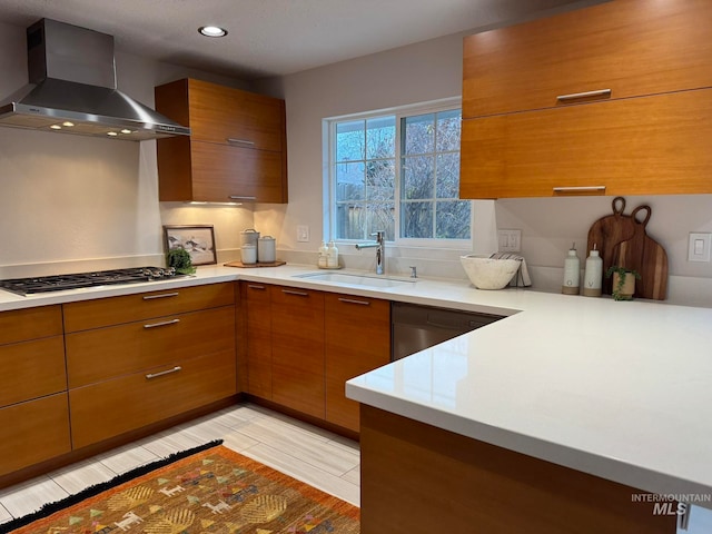 kitchen featuring wall chimney exhaust hood, light hardwood / wood-style floors, sink, and stainless steel gas cooktop