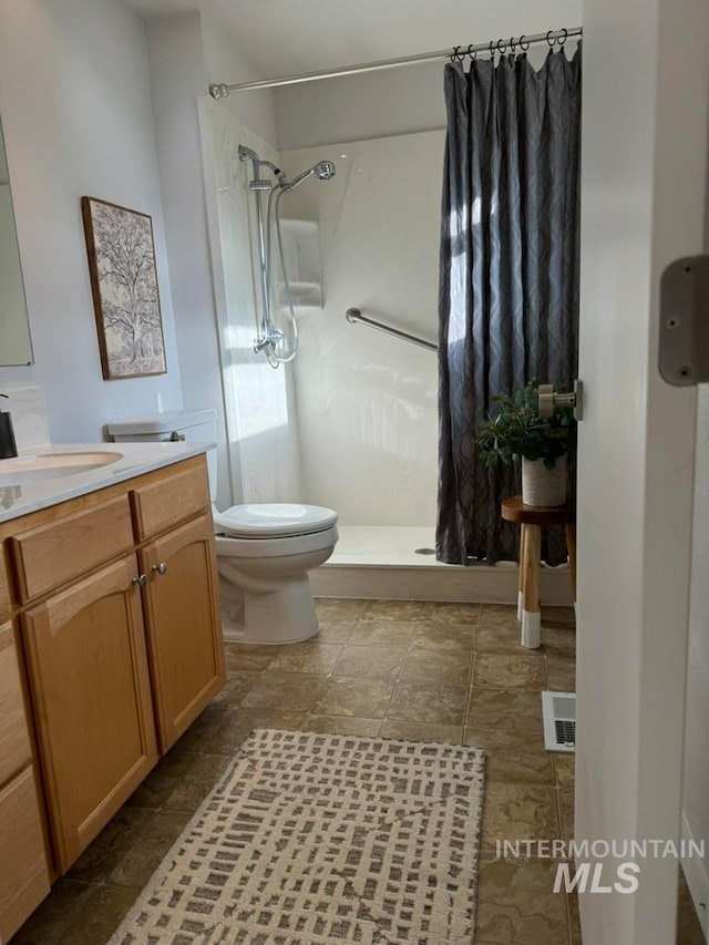 bathroom with a shower with curtain, vanity, and toilet