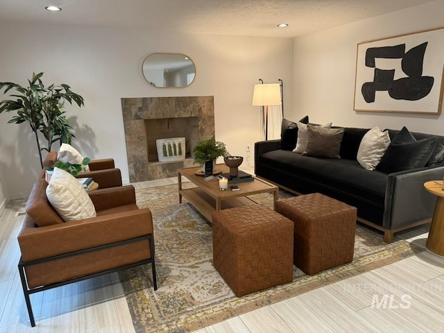 living room featuring a tile fireplace and light hardwood / wood-style floors