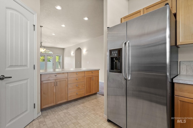 kitchen with stainless steel fridge, recessed lighting, light countertops, baseboards, and light floors
