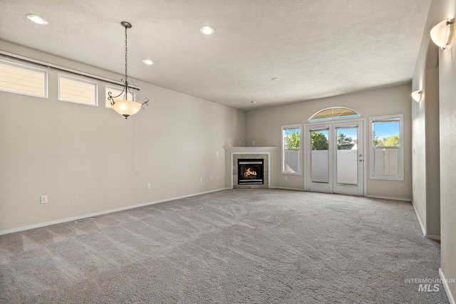 unfurnished living room featuring carpet flooring, recessed lighting, baseboards, and a fireplace