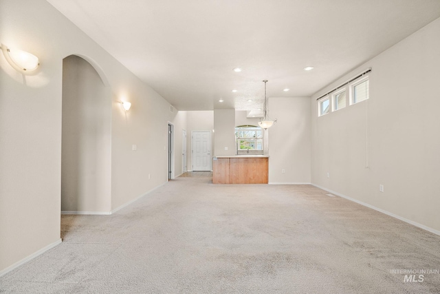 unfurnished living room with recessed lighting, light carpet, and baseboards