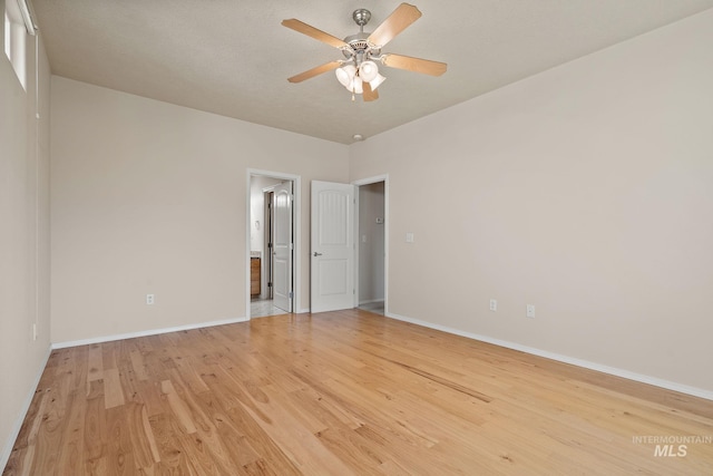 unfurnished room with light wood-type flooring, baseboards, and a ceiling fan