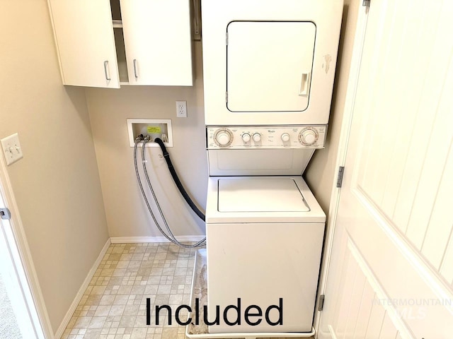 laundry area with stacked washer and clothes dryer, cabinet space, and baseboards