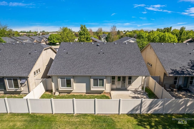back of property with a patio, a shingled roof, and a residential view