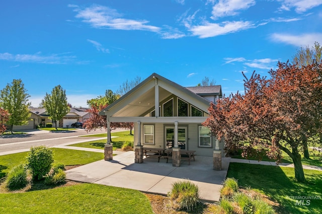 back of property featuring covered porch and a yard