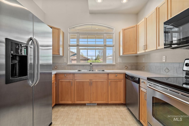 kitchen featuring appliances with stainless steel finishes, a sink, light countertops, recessed lighting, and tasteful backsplash