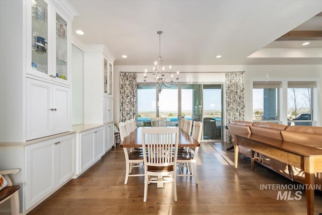 dining room with a wealth of natural light, a notable chandelier, and wood finished floors