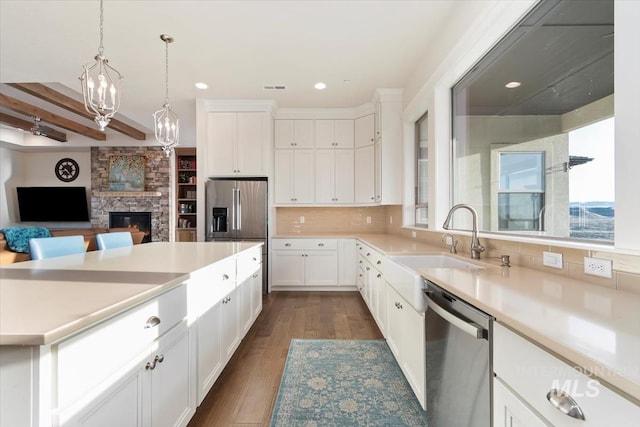 kitchen with visible vents, dark wood-style flooring, stainless steel appliances, decorative backsplash, and light countertops