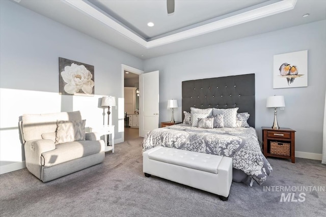 bedroom with a tray ceiling, baseboards, ceiling fan, and carpet flooring