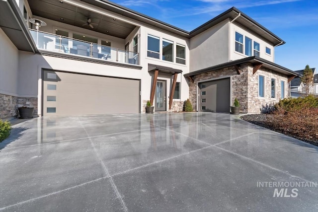 contemporary house featuring stucco siding, stone siding, concrete driveway, an attached garage, and a balcony