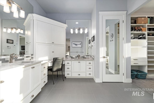 bathroom with vanity and a walk in closet