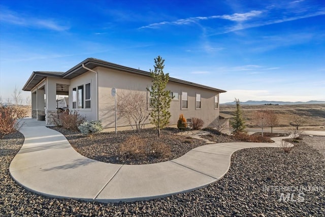 view of side of property featuring stucco siding and a mountain view