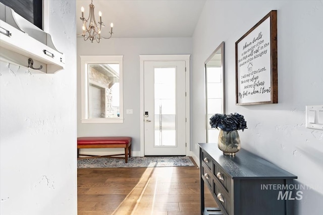 interior space featuring baseboards, a notable chandelier, and dark wood-style floors