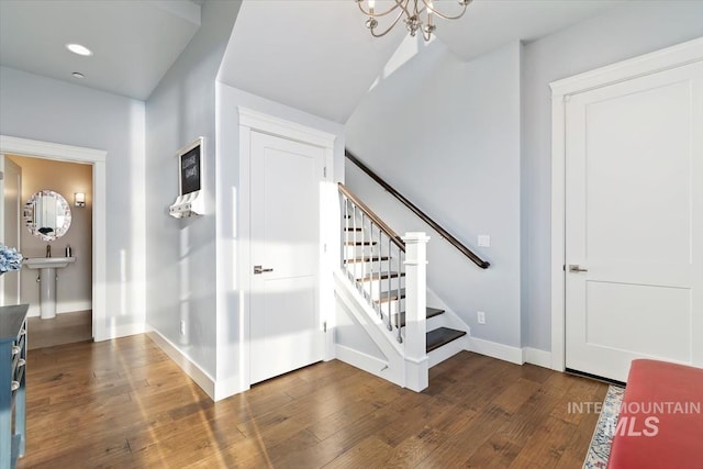 stairs featuring recessed lighting, baseboards, a notable chandelier, and wood finished floors