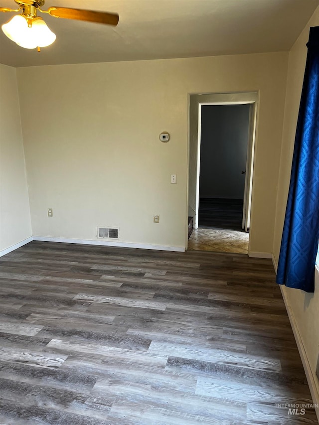 empty room featuring ceiling fan and dark hardwood / wood-style flooring