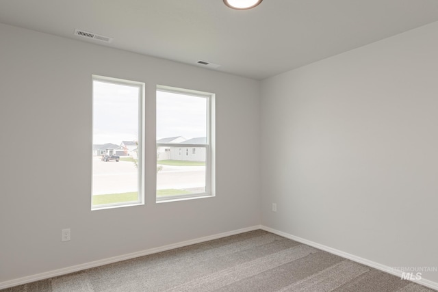 carpeted empty room with baseboards and visible vents
