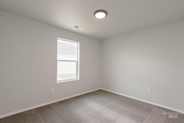 carpeted spare room featuring visible vents and baseboards