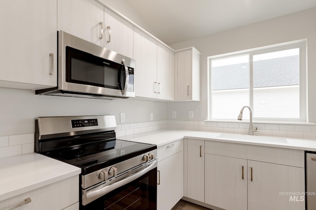 kitchen with light countertops, a sink, and stainless steel appliances