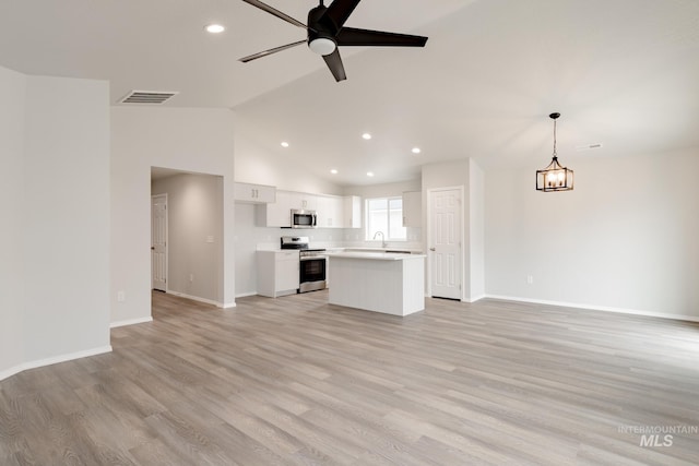 unfurnished living room with baseboards, a sink, a ceiling fan, and recessed lighting