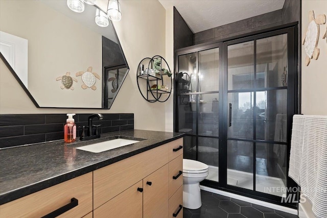 bathroom with vanity, backsplash, tile patterned floors, toilet, and an enclosed shower