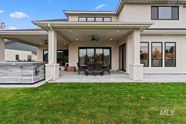 rear view of house with a yard, a patio, a hot tub, and ceiling fan