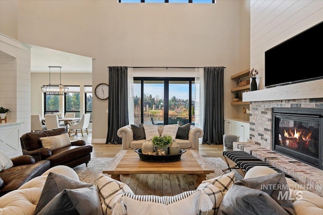 living room with a high ceiling, light hardwood / wood-style floors, and plenty of natural light