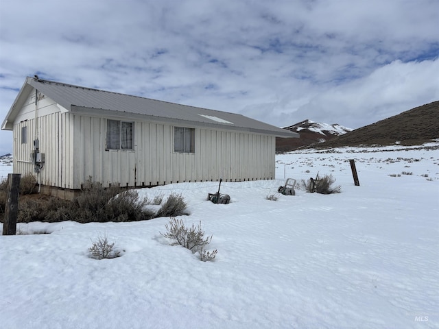 view of snowy exterior with metal roof